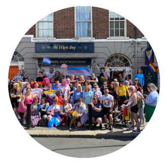 A large community groups with flags pose for a picture smiling outside Old Music Shop Restaurant Dublin ahead of Pride Parade in 2023