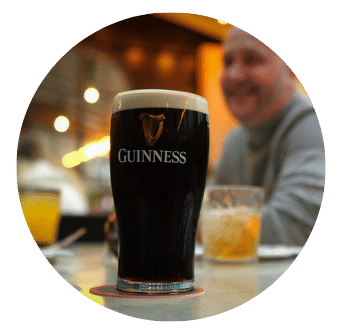 Pint of Guinness with man smiling in Old Music Shop Restaurant Garden Terrace area in Dublin 1