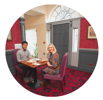 Man and Woman sit at a table in front of elegant Georgian Door in Old Music Shop Restaurant Dublin