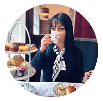 Woman drinks cup of tea in Old Music shop Restaurant in Dublin with Afternoon Tea Stand