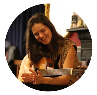 Beautiful Singer smiles and claps while playing guitar at Old Music Shop Restaurant on Culture Night in Dublin