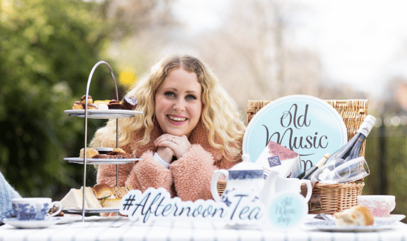 Woman smiles beside Afternoon Tea in Dublin with Prosecco