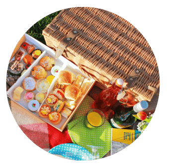 Picnic Hamper with Afternoon Tea Alfresco Box from Old Music Shop Restaurant Dublin with sandwiches, cakes, scones, paper plates, prosecco and plastic flute glasses. Laid out on picnic rug