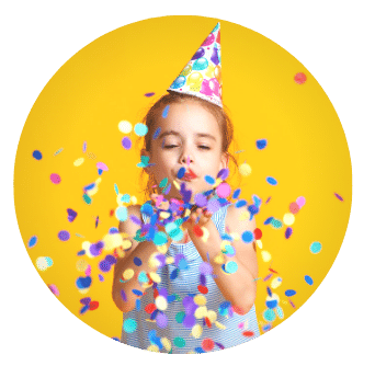 young girl in party hat blows confetti with yellow background