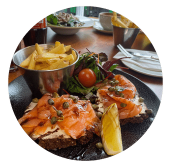 Smoked Salmon with capers and cheese on brown bread with fries and salad 