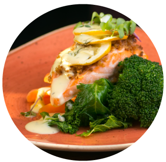 Mothers Day Baked Salmon with preserved Lemon and parsley sauce Broccolli, Kale and carrots on an orange plate in the Old Music Shop Restaurant Dublin Ireland